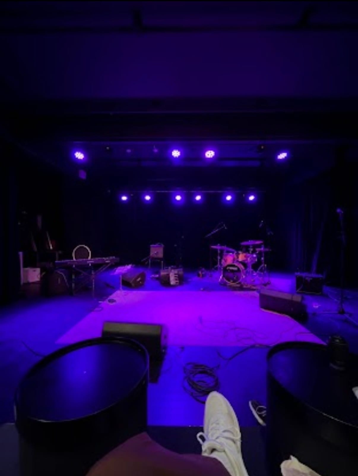 Lilla opplyst scene rigget for konsert med instrumenter